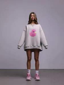 Felpa grigia oversize con simpatica stampa di papera rosa indossata da modella