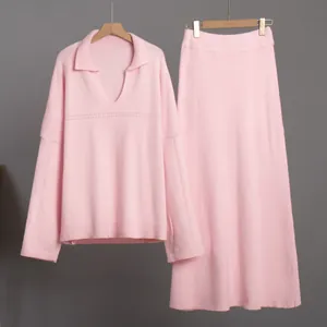 Close-up of pink V-neck knit sweater and matching midi skirt set