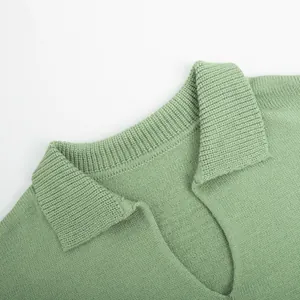 Close-up of the knitted V-neck collar of a sage green stylish sweater set.