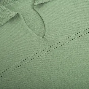 Close-up of sage green V-neck knitted sweater featuring delicate openwork details.