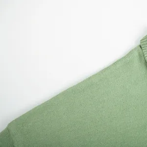 Macro detail view of sage green knit fabric showing fine texture and ribbed edge finish.
