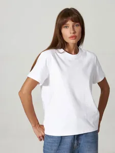 Modell trägt ein klassisches weißes T-Shirt mit Rundhalsausschnitt und lässigen Jeans