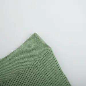 Detailed close-up of the ribbed knit fabric on a minimalist green winter sweater skirt set