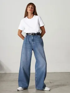 Minimalistisches weißes Damen-T-Shirt mit Rundhalsausschnitt und blauer weit geschnittener Jeans