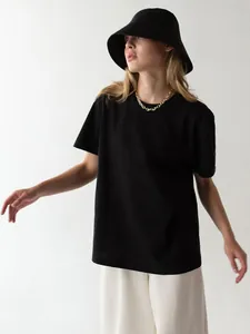 Minimalistisches schwarzes Rundhals-T-Shirt, getragen von Model mit Fischerhut und Kette
