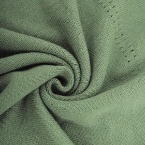 Detailed macro shot of premium sage green knitted fabric showing fine texture and softness