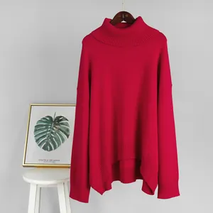 Oversized red turtleneck sweater with thick knit texture and wide ribbed cuffs