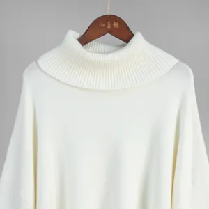 Close-up detail of a soft white turtleneck knit sweater featuring a ribbed collar design.