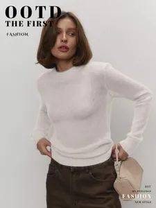 Close-up of white mohair sweater showing semi-sheer knit texture on a fashion model