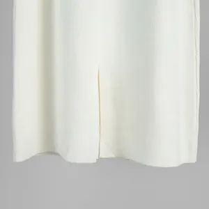 Detailed macro view of the white ribbed knit skirt hem featuring a stylish center slit design