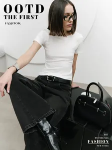 Close-up shot of a model wearing a minimalist white slim fit T-shirt with black jeans