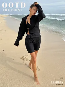 Minimalist black cotton long-sleeve shirt and shorts leisure set shown on beach