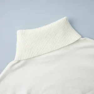 Macro detail showing the soft white ribbed turtleneck collar of this knitted winter sweater