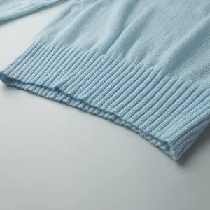 Close-up of ribbed hem and fine knit texture on light blue sweater