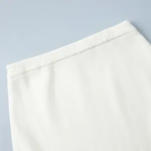 Close-up of the elastic waistband and soft knit texture of a white winter sweater skirt set