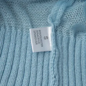 Close-up of washing label on blue mohair knit sweater showing material composition