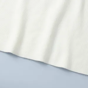 Close-up of white ribbed knit fabric showing soft texture and fine vertical stripes