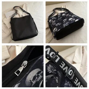 Detailweergaven van nylon crossbodytas met schedelprint, zilveren rits en 'LOVE'-band.