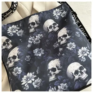 Detail van een nylon crossbodytas met een gotische schedel- en bloemenpatroonprint.