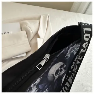 Detailopname van een nylon crossbodytas met schedelprint en riem met LOVE-letters