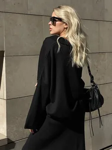 Elegant black oversized knitted sweater and skirt set for women in urban setting