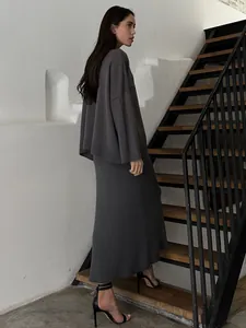 Side view profile of a charcoal grey knit set featuring a loose sweater and maxi skirt