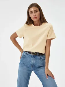 Model trägt ein lässiges beige Kurzarm-T-Shirt mit Rundhalsausschnitt für den Sommer