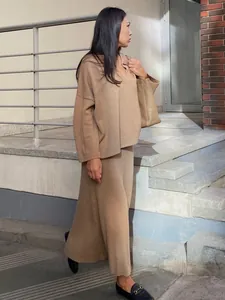 Elegant camel knit set featuring a V-neck sweater and midi skirt shown on model outdoors