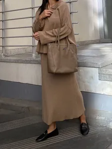 Detail showing the minimalist fit and texture of the brown knit sweater and skirt set