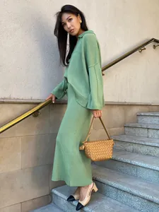 Asian model wearing a stylish green V-neck knitted sweater and maxi skirt set outdoors