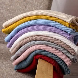 Stapel bunter, schmal geschnittener Rippstrickpullover mit Stehkragen in vielen Farben