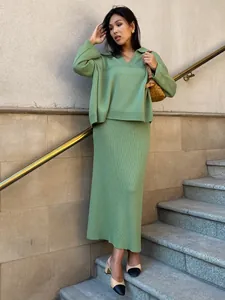 Detail view of a green two-piece knit set featuring a V-neck sweater and a maxi skirt.