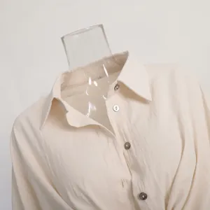 Detail view of a beige casual loose shirt showing the collar and textured buttons
