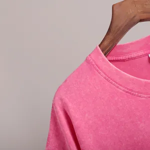 Detail shot of the ribbed neckline on a pink acid-washed vintage cotton T-shirt.