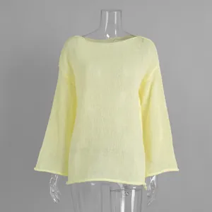 Detail view of the sheer light yellow hollowed-out knit fabric and flared sleeve design