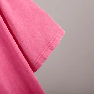 Close-up detail of washed pink cotton T-shirt sleeve showing fabric texture and stitching