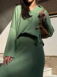 Detailed look at a stylish green V-neck knit sweater paired with a matching ribbed midi skirt