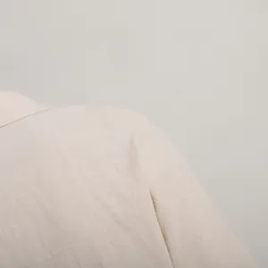 Detailed view of the beige linen-textured fabric on a loose-fit summer vacation shirt