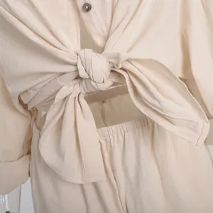 Close-up detail of the tie-front knot and breathable textured fabric on beige shirt set
