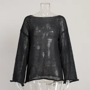 Macro view of sheer black hollow knit texture and flared sleeve detail on sweater