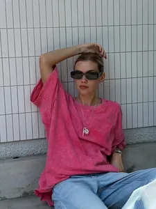 Relaxed fit pink acid wash cotton t-shirt worn by model against a white tiled wall background