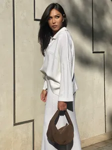 Detailed side view showing the texture of white knitted sweater and matching midi skirt