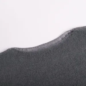 Close-up macro view of a grey hollow-out knitted sweater showing the fine neckline texture