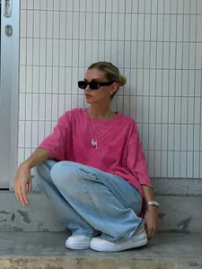 Street style model in a pink washed oversized T-shirt and light blue denim jeans