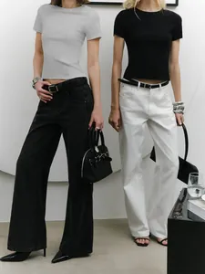 Lifestyle shot of slim fit cropped t-shirts in grey and black paired with wide-leg jeans.