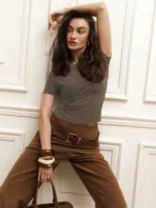 Detail shot of a slim-fit olive cropped T-shirt on a model with neutral background.