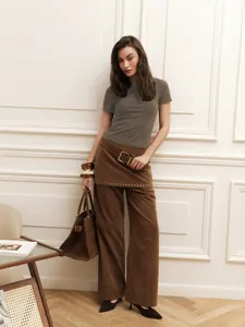 Model wearing a slim-fit grey short-sleeved cropped t-shirt in a stylish indoor setting.