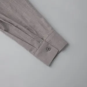 Detail of cotton shirt cuff showing texture and button on grey long-sleeved set