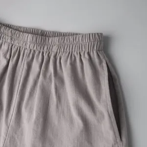 Close-up of elastic waistband and side pocket detail on grey cotton shorts