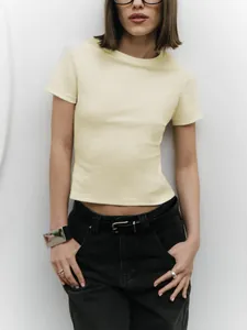 Detailed view of a women's pale yellow slim-fit crop top t-shirt with short sleeves